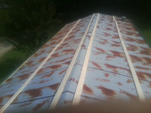 Rusted metal roof panels with new wood purlins before replacement — Storm Damage Roof Repair in East Lyme by Roofing Brothers
