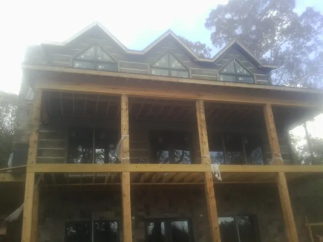 Dormers and porch framing on a large log home under construction — Roof Coating work by our crew in East Lyme