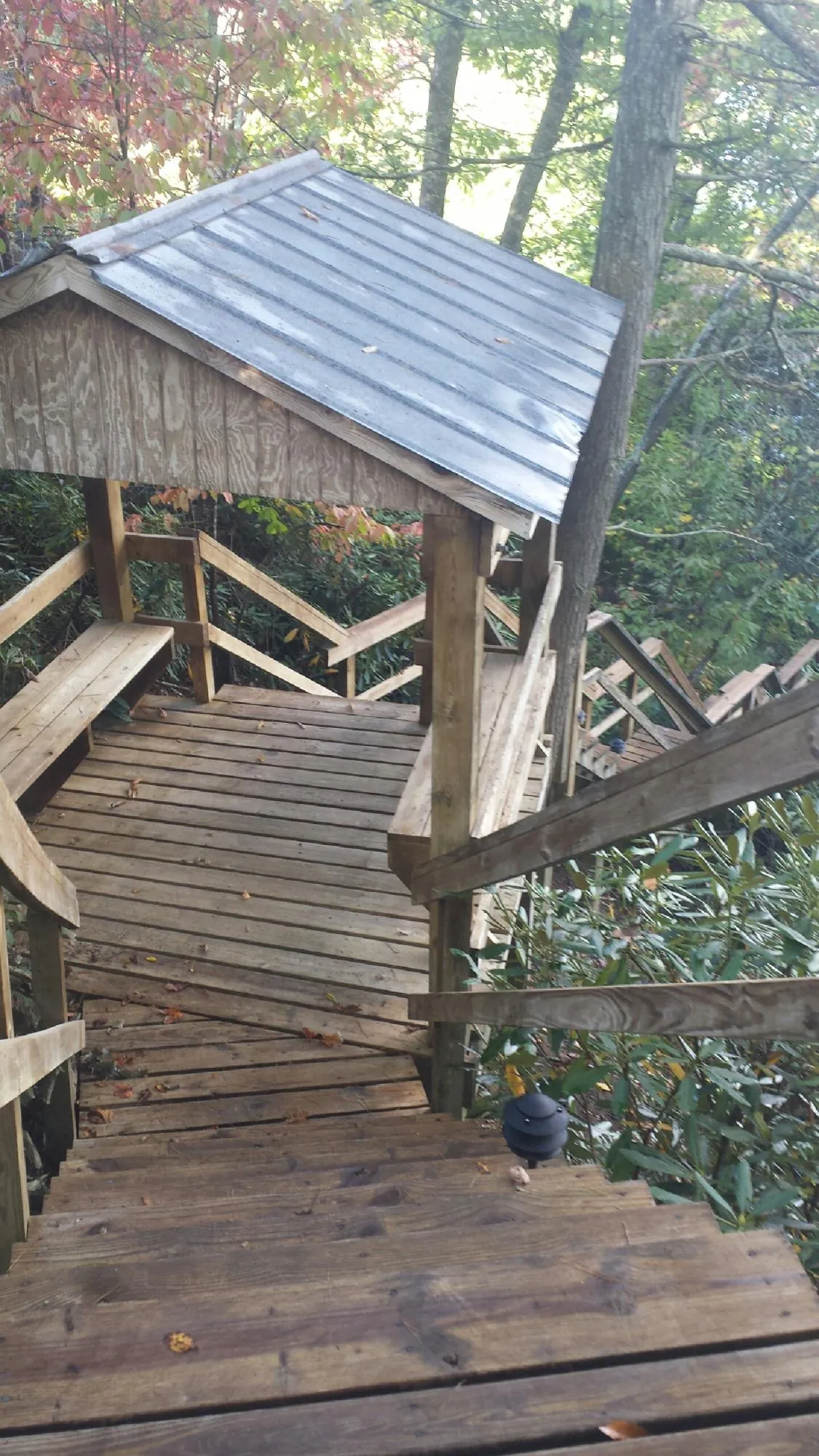 Metal roofed shelter over wooden steps on a wooded walkway — Skylight Repair & Installation work by our crew in East Lyme
