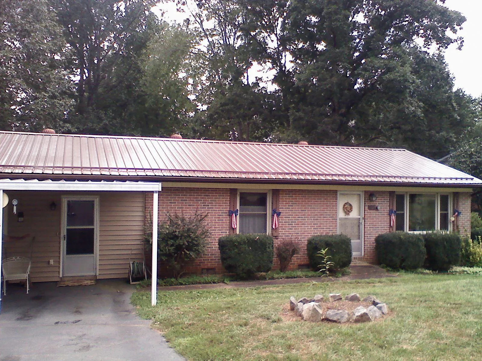 Bronze metal roof and carport on a brick ranch home — Roof Repair work by our crew in East Lyme